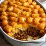 Grease a casserole dish and spread the beef mixture evenly across the bottom Recipe