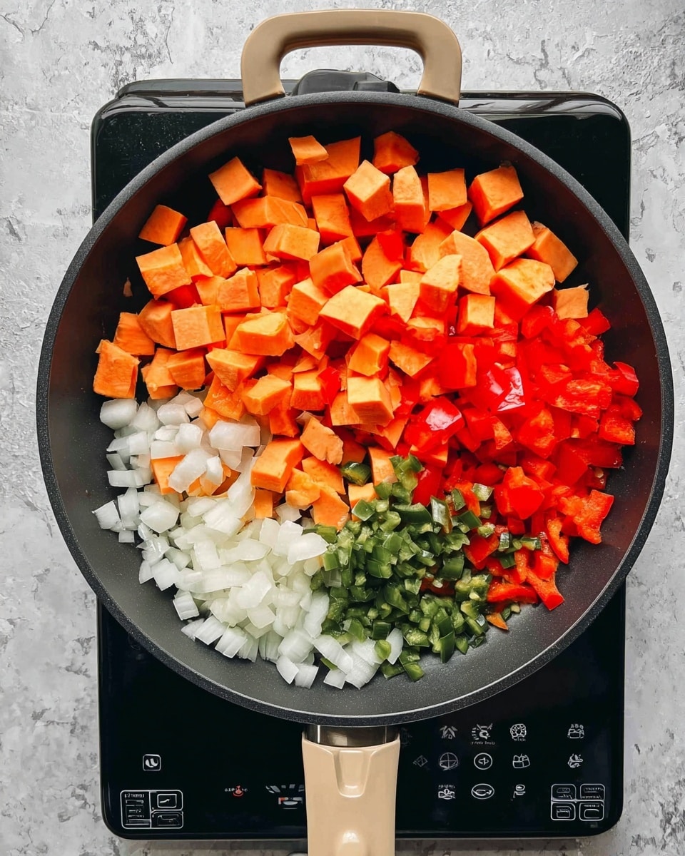 A black pan with beige handles sits on a stove with a black and white control panel. Inside the pan, there are four layers of chopped vegetables: at the bottom left is white diced onion, next to it on the right is green diced chili, above the onion and chili are bright red chopped bell peppers, and the top left half of the pan is filled with orange cubed sweet potatoes. The background surface is a white marbled texture. Photo taken with an iphone --ar 4:5 --v 7