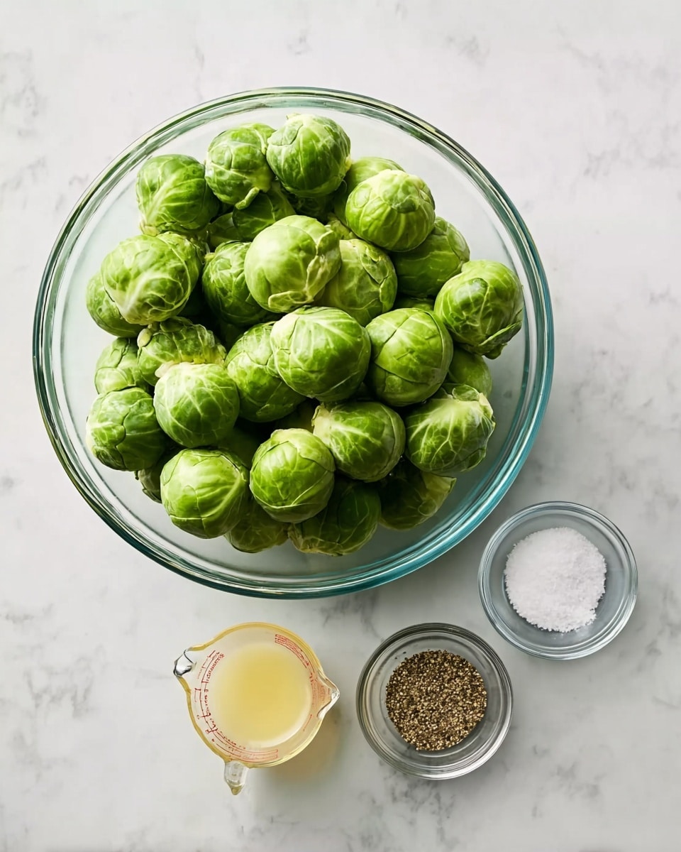 A clear glass bowl filled with bright green Brussels sprouts sits on a white marbled surface. To the right of the bowl, there are three smaller clear glass containers arranged in a small triangle: one measuring cup with a pale yellow liquid, one small round bowl with coarse salt, and one small round bowl with ground black pepper. The overall look is clean and simple, with fresh ingredients ready for cooking. Photo taken with an iphone --ar 4:5 --v 7