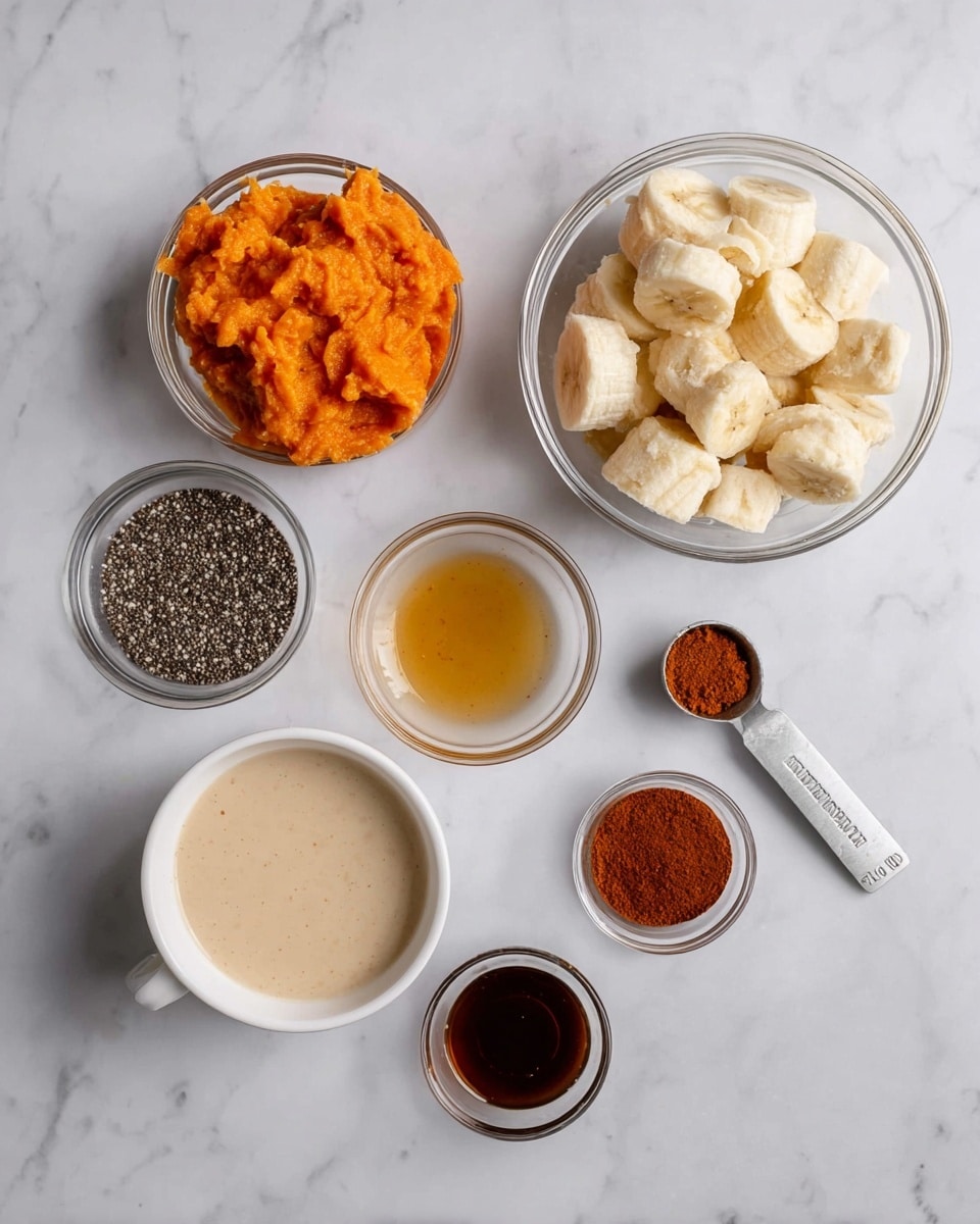 The image shows seven clear or white small bowls placed on a white marbled surface, each containing a different ingredient. At the top right is a clear bowl filled with peeled, frozen banana pieces, light cream in color with a soft texture. To the top left is a clear bowl of mashed sweet potato, bright orange and smooth in texture. Below the bananas is a silver measuring spoon filled with chia seeds, small black and white specks. Under the sweet potato bowl on the left is a white bowl filled with creamy beige liquid, likely a milk or cream. In the middle are two small clear bowls, the top one holds a golden-brown syrup and the bottom one a dark brown liquid, possibly vanilla extract. At the bottom right is a clear bowl with ground cinnamon, a reddish-brown powder. Everything is laid out clearly with good lighting. photo taken with an iphone --ar 4:5 --v 7