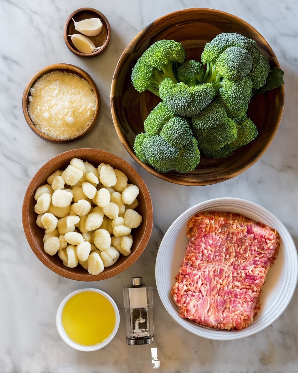 The image shows a collection of cooking ingredients placed on a white marbled surface. Starting from the top right, there is a wooden bowl filled with fresh green broccoli heads. Next to it, on the left side, there is a smaller wooden bowl holding three peeled garlic cloves. Below that, a larger wooden bowl contains grated pale yellow cheese. On the lower left side, another wooden bowl is filled with small, pale gnocchi pieces. To the right, a white bowl holds a square portion of pinkish ground meat with visible bits of fat. Below the meat, a small white bowl contains yellow olive oil, and beside it, there is a clear pepper grinder. The arrangement is neat and each element has distinct colors and textures. photo taken with an iphone --ar 4:5 --v 7